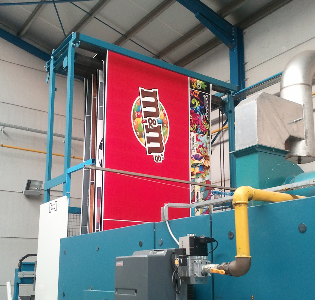 Freshly printed red felt carpet emerging from the production line